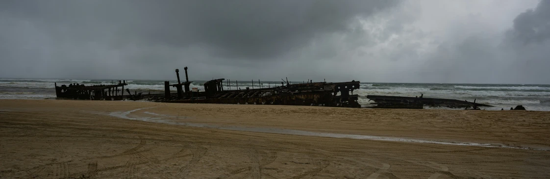 a ship sits on the beach next to a shoreline