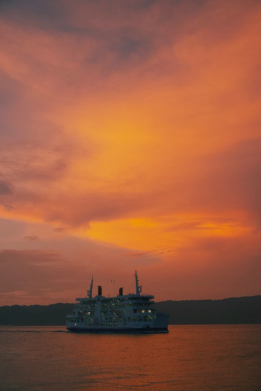 a ferry ship sits at dusk under a sunset sky