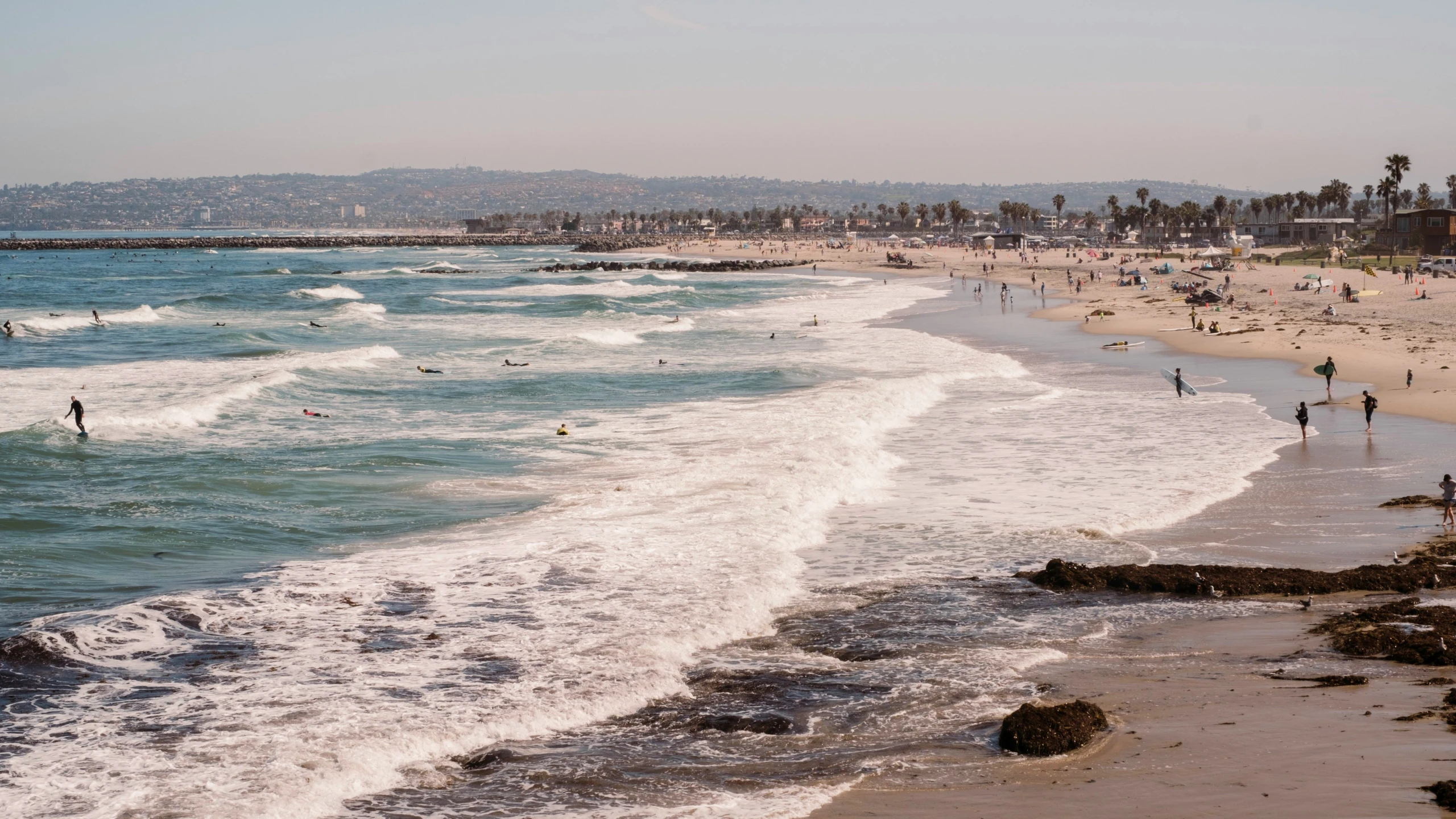 a beach with people swimming and laying on top of it