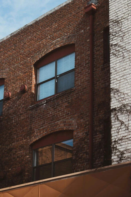 a big building that has two windows and several bricked off buildings