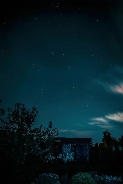 there is a small cabin on a hill at night