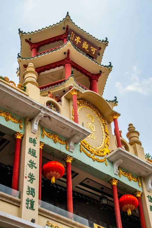 a clock tower with red and gold pillars under it