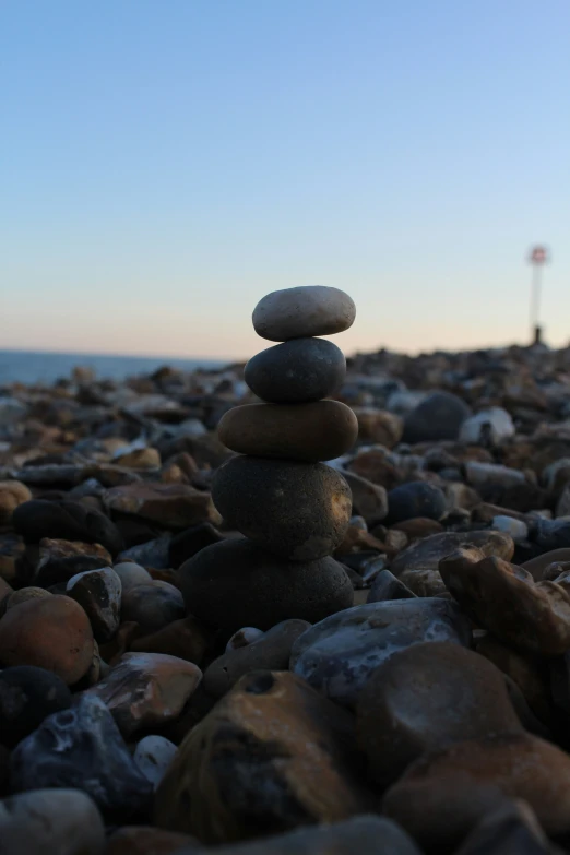 rocks and pebbles stacked on each other near the water