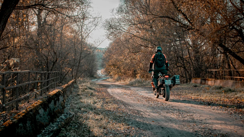 a man riding his bicycle down a rural country road