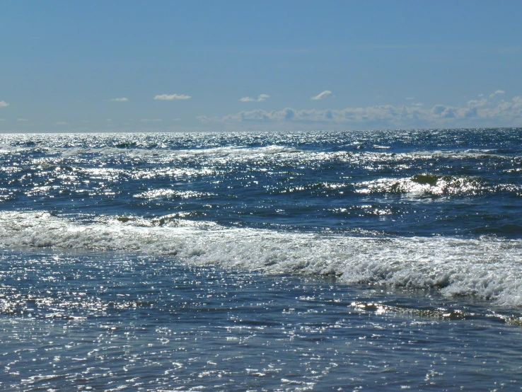 the waves are moving toward shore on a sunny day