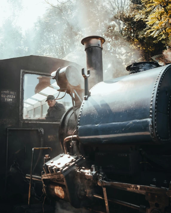 a steam locomotive engine with a man looking out the window