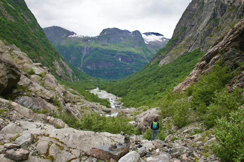 man looking over the edge of rocky valley