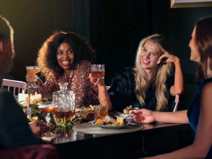 four friends are sitting at a table enjoying dinner together