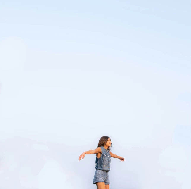 girl skateboarding in the desert with her hand out