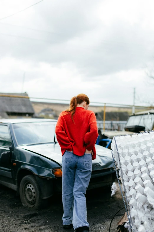 a woman in red standing in a parking lot