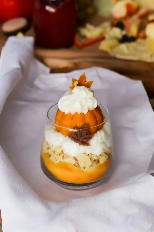 a dessert of oranges, whipped cream and nuts in a glass