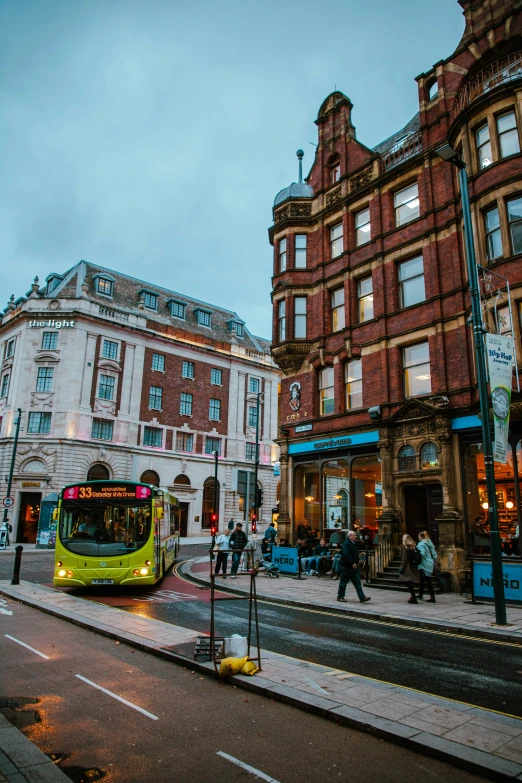 a yellow bus is parked by a busy street