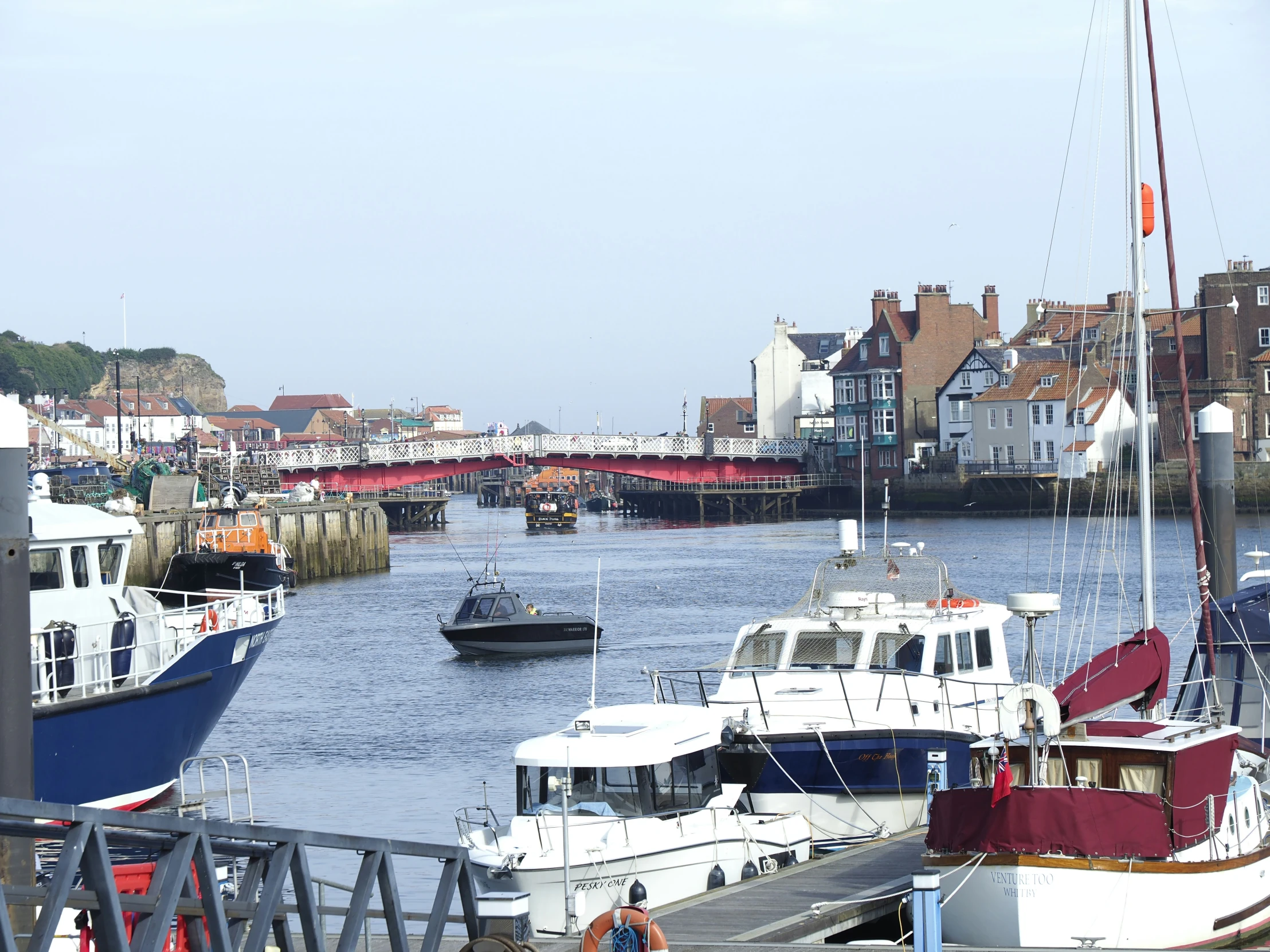 boats sit parked at the dock near houses