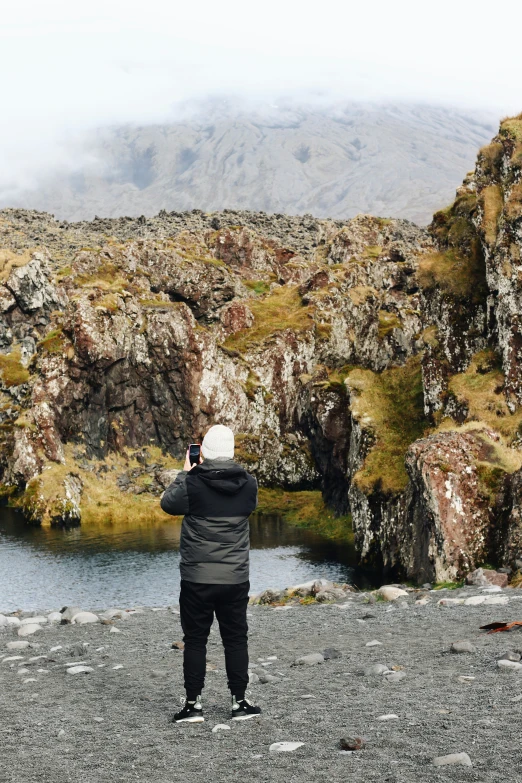 a person standing on a cliff taking a po