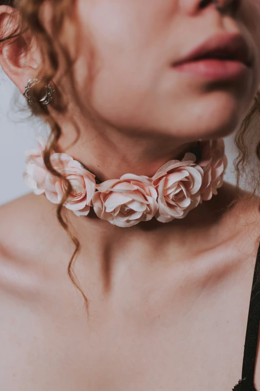 a close up of a person wearing a rose necklace