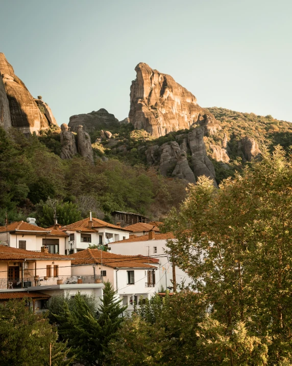 houses near trees under mountain with trees and rock