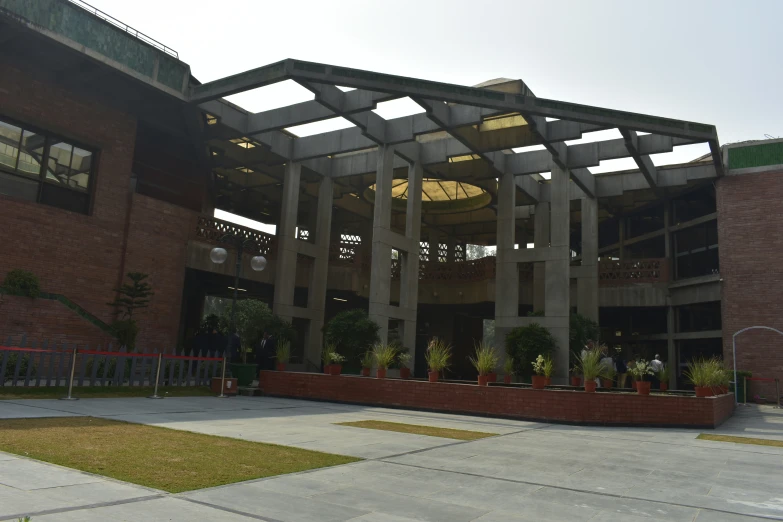 the front of a large building with many plants growing inside of it