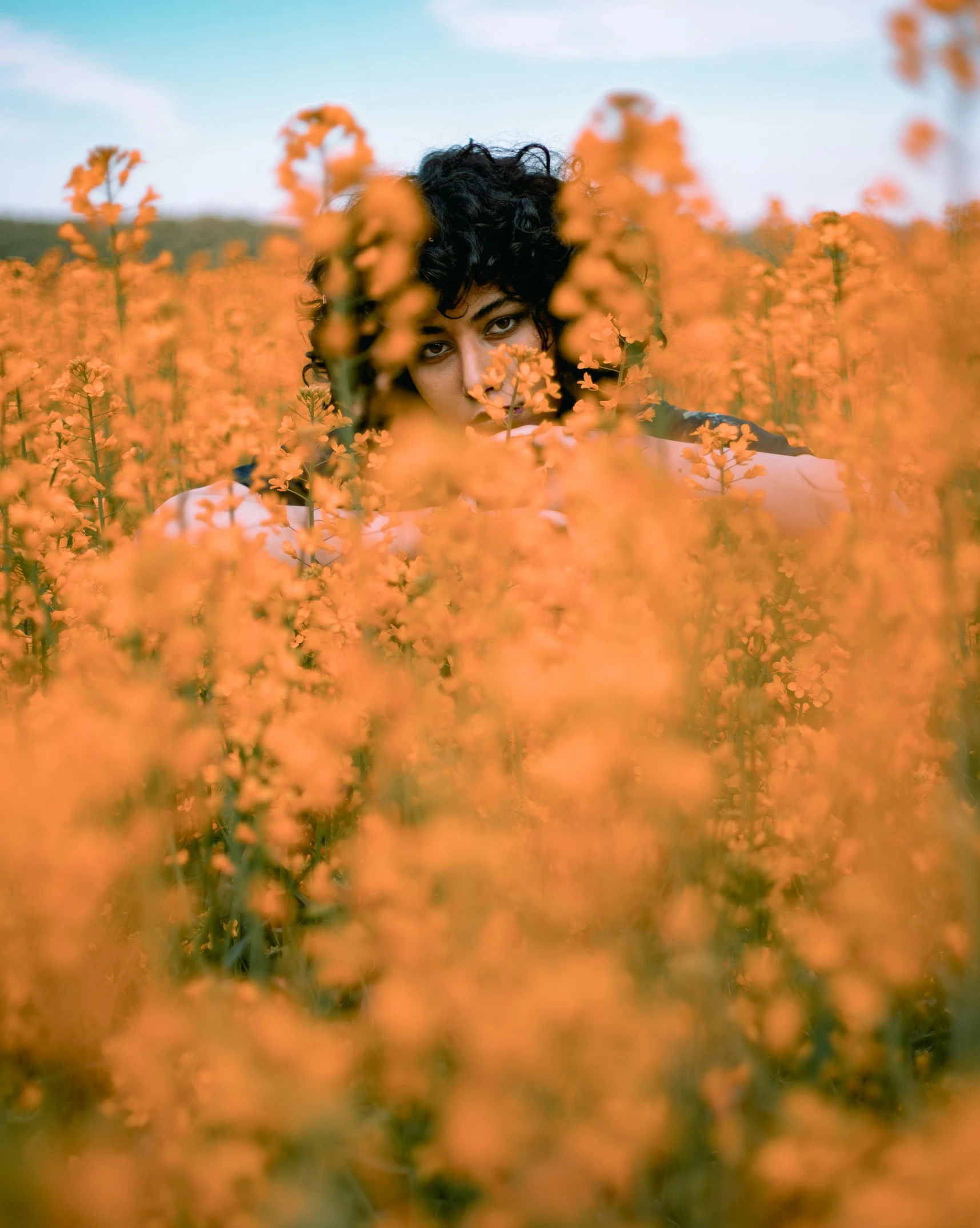 a man with black hair is looking at the camera