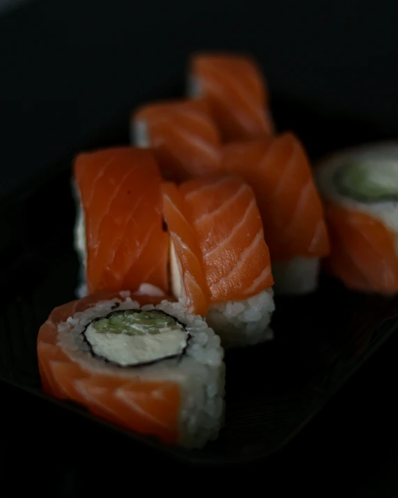 a black plate filled with sushi and ers