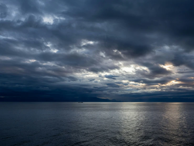 there is a boat in the water under a stormy sky