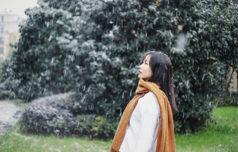 woman in white shirt and orange scarf with rain