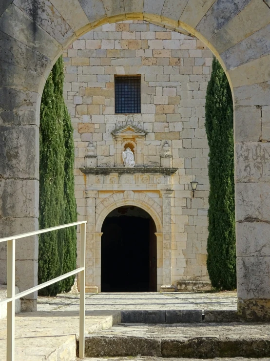 a stone gate that is near trees and stairs