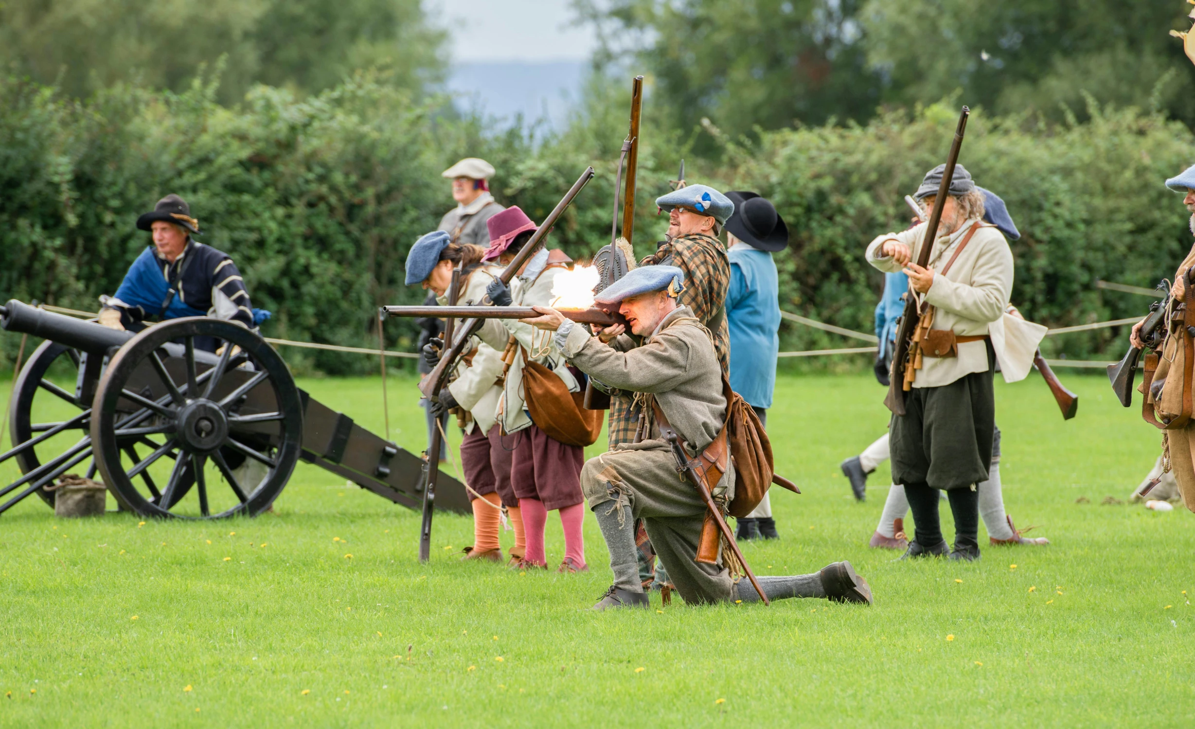 a group of people standing around a field holding guns