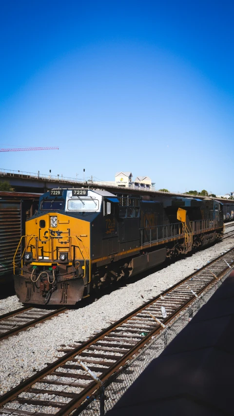 a black and yellow train on tracks next to tracks