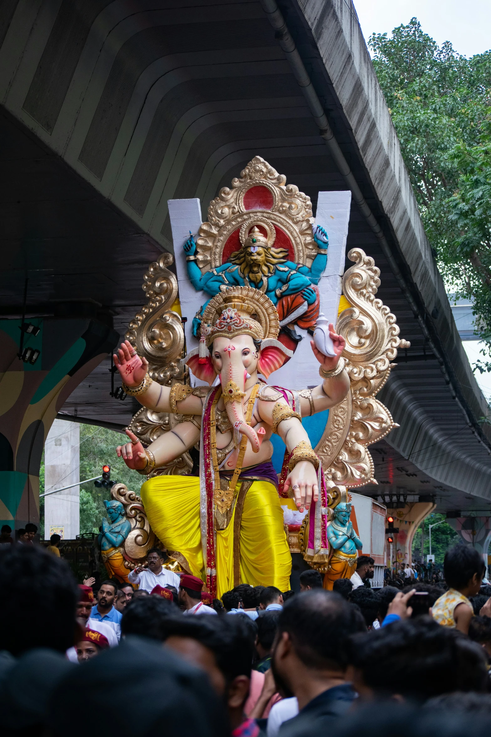 a very large crowd near a tall sculpture