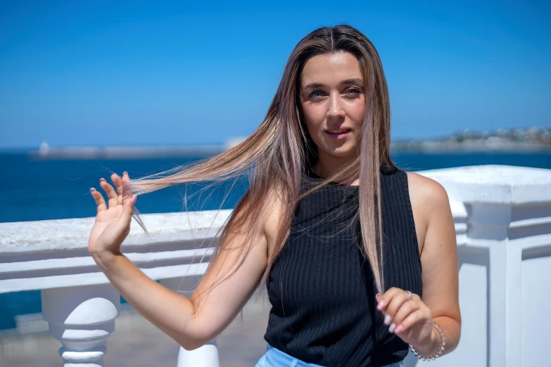 a woman with long hair is standing on a bridge