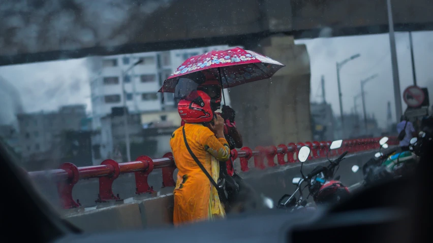 the person in yellow is holding an umbrella