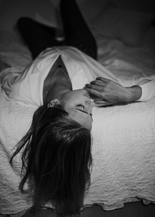 a woman laying on top of a white bed