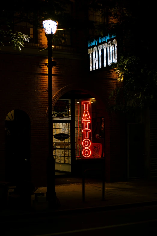 the dark storefront has two lighted signs