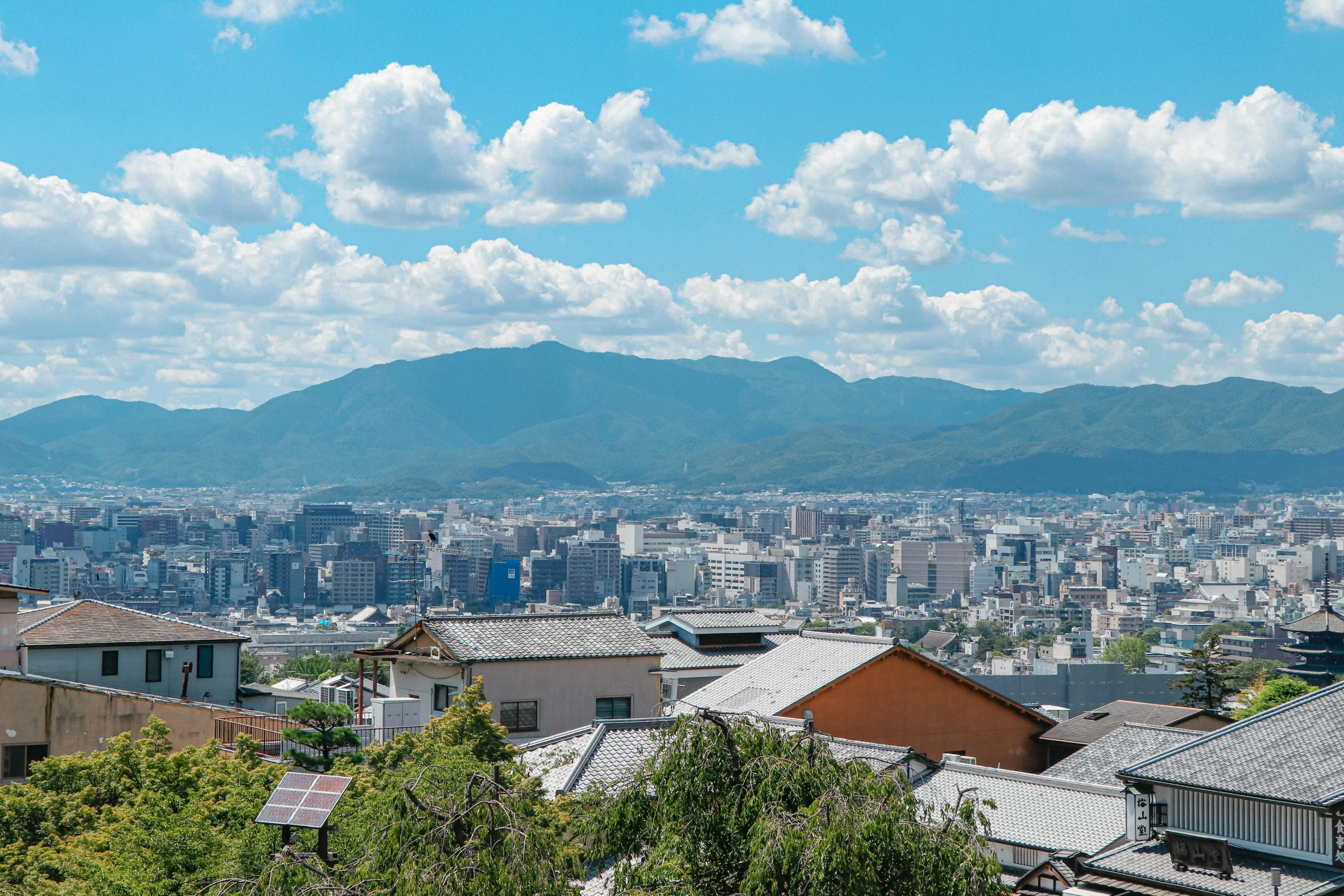 a group of buildings next to a hill and a cityscape