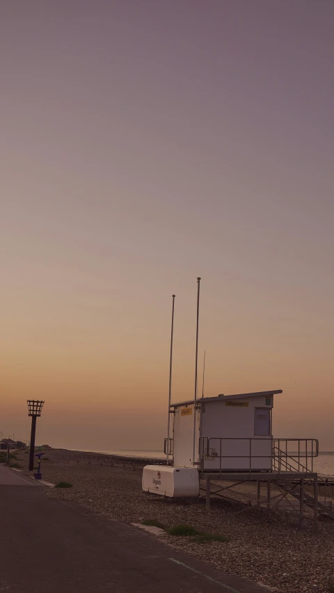 an antenna stand near the ocean at sunset