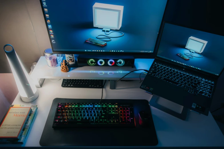 a computer desk with laptop computer and other electronic items