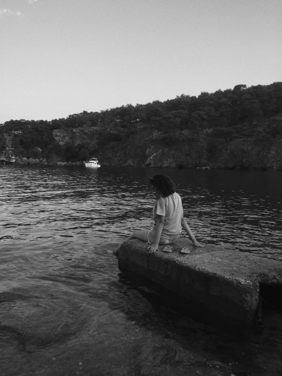 a man on a log at the edge of water