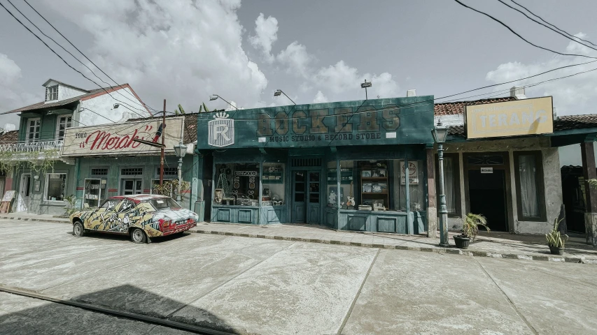 an old - fashioned car is parked in front of several stores