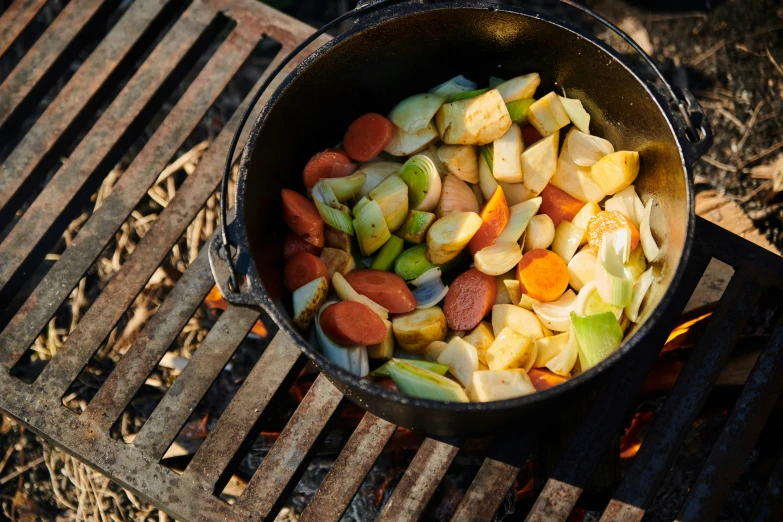 a bowl of diced up vegetables on top of an open fire pit