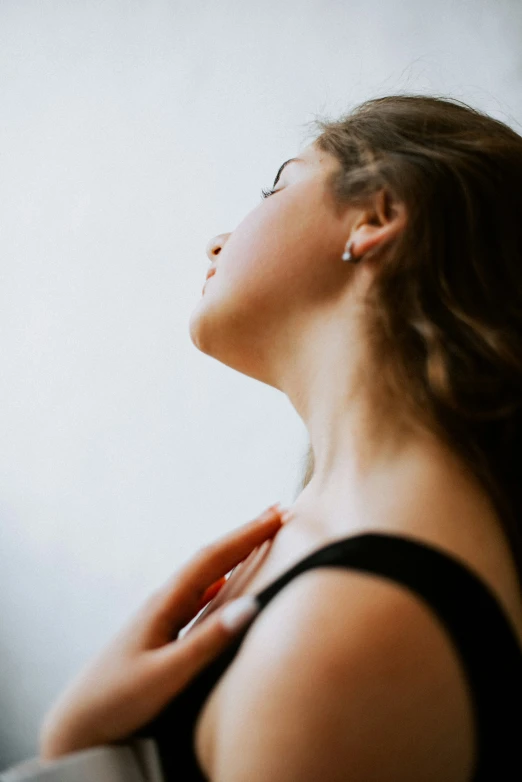 woman staring upwards at soing while sitting by a window