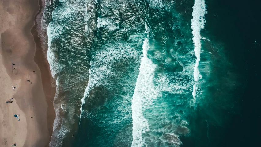 an aerial view of the ocean and the sandy beach