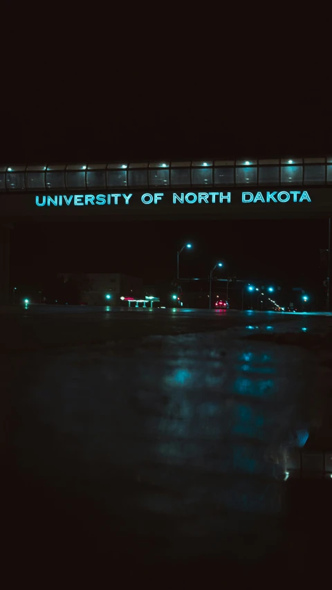 a bridge has lit up a bright neon sign that reads university of north dakota