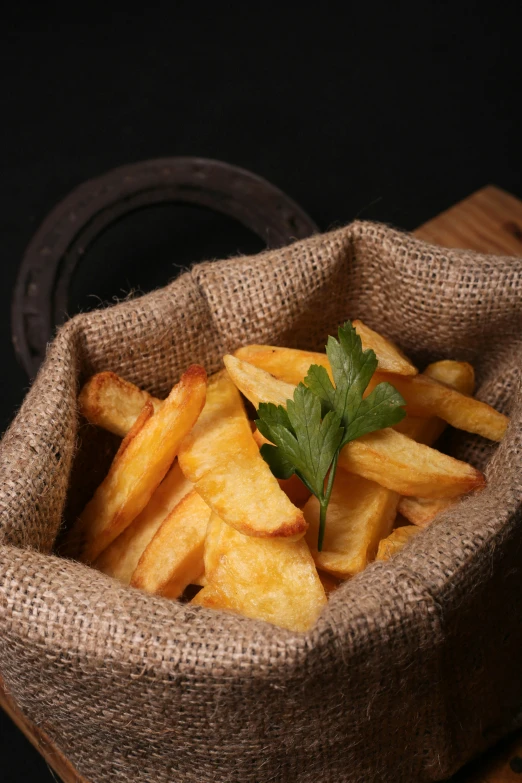 a sack full of french fries with a parsley leaf