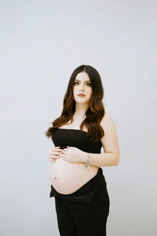 a pregnant woman wearing black poses for the camera