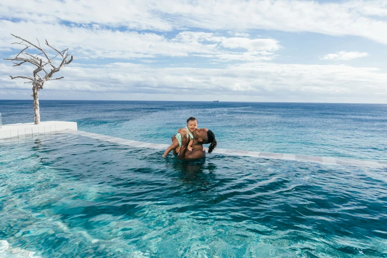 a man is sitting in the water with a drink