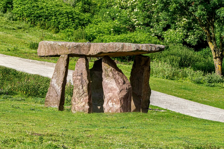 stone picnic table in front of grassy trail