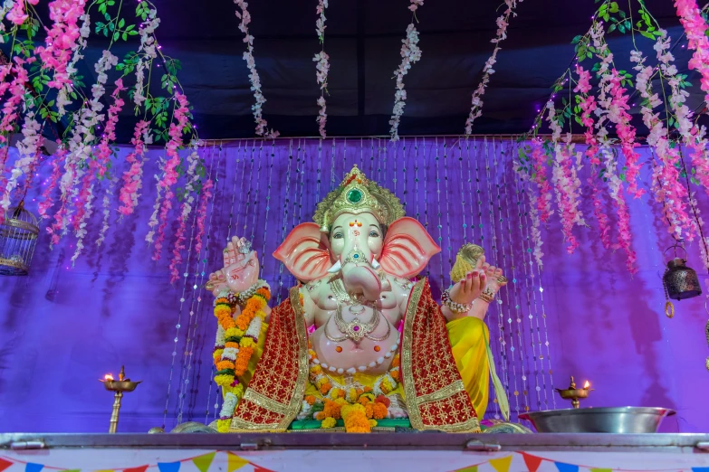 an idol in a home decorated with purple and white flowers