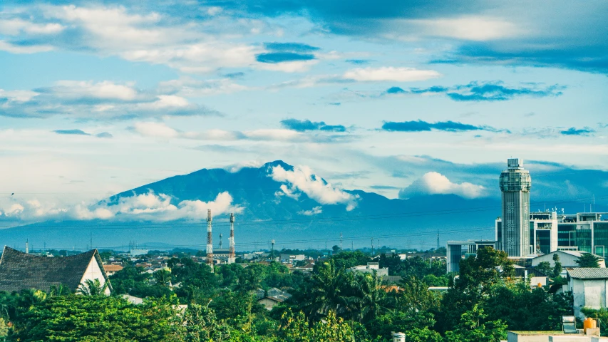 a city with buildings and a tall mountain in the distance