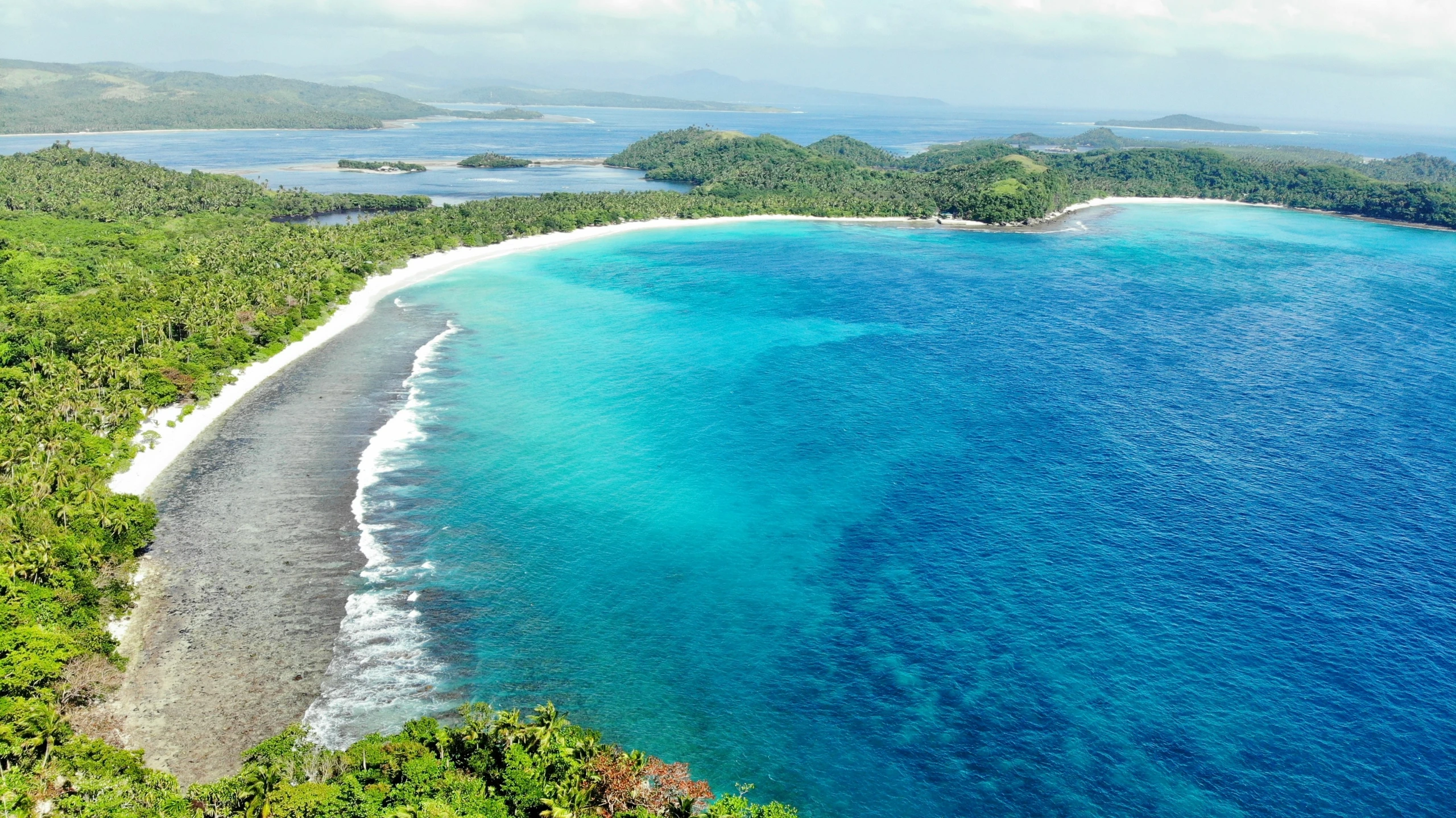 the water and trees in front of an island are bright blue