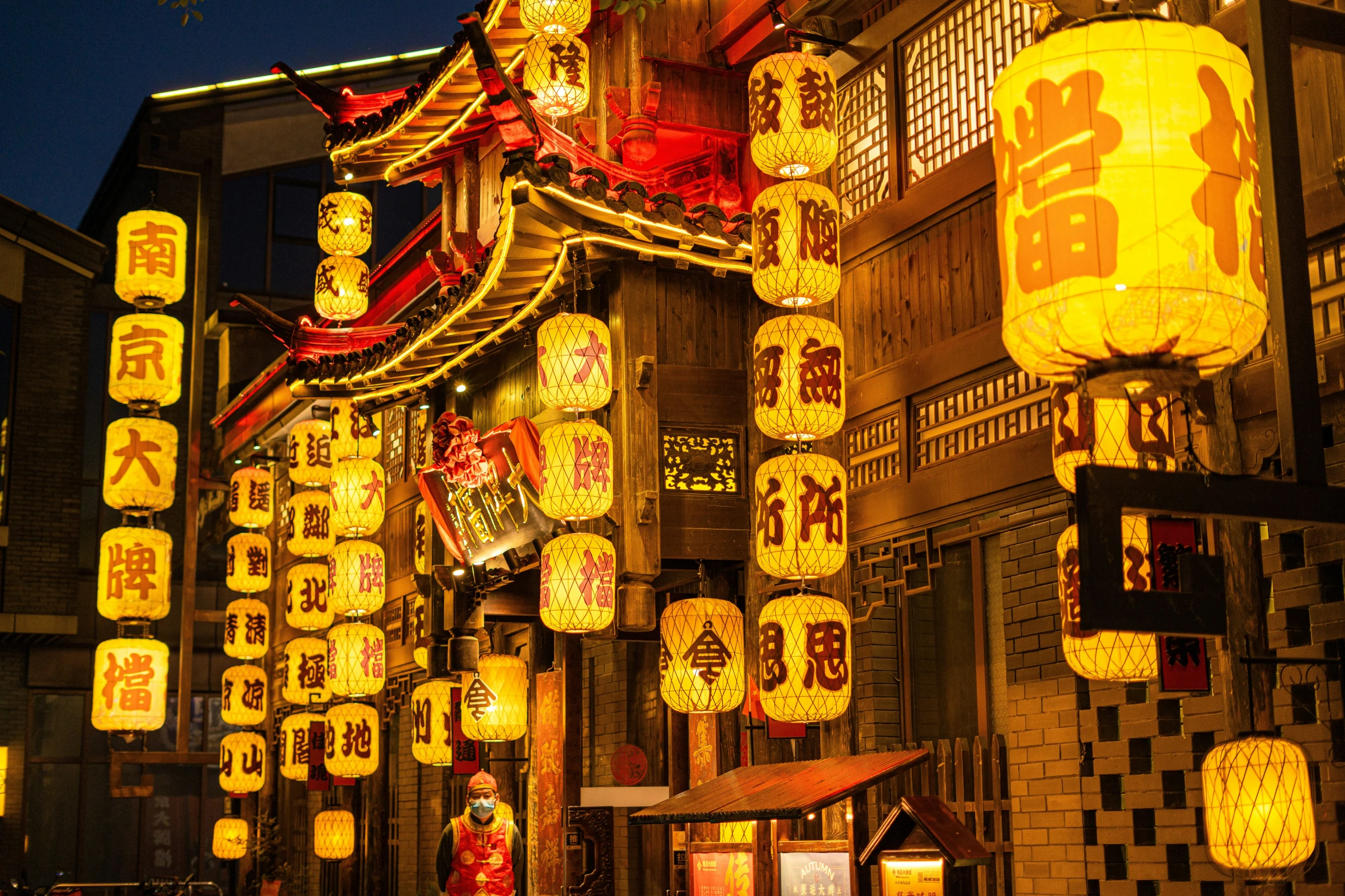 lighted lanterns hang on an urban street at night